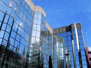 Surety bonding - The image shows a window glass building with a colored blue sky.