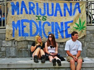 Medical marijuana - The image shows a group seating with a banner a their back.