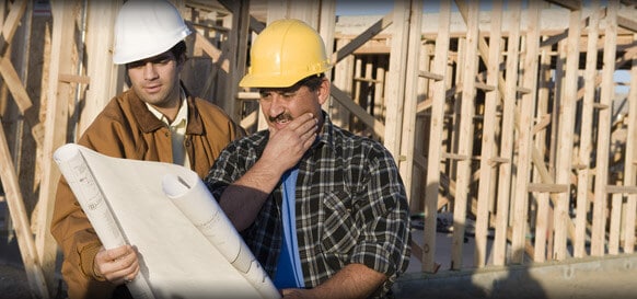 Where to buy a surety bond image - The image shows two contractor looking at the blueprint in a constructed area.