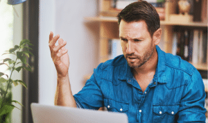 Man looking at a computer screen and reading about Alaska bonds and AK performance bonds