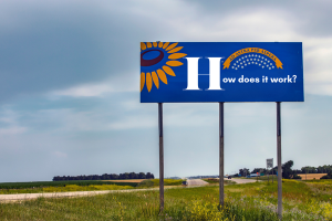 Kansas highway billboard with sunflower state emblem and text 'How does it work?' addressing the mechanics of bid bonds in Kansas.