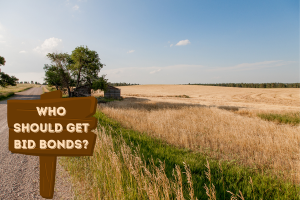 Scenic view of Nebraska countryside with a wooden sign asking "Who Should Get Bid Bonds?" inviting contractors to explore bid bond eligibility.