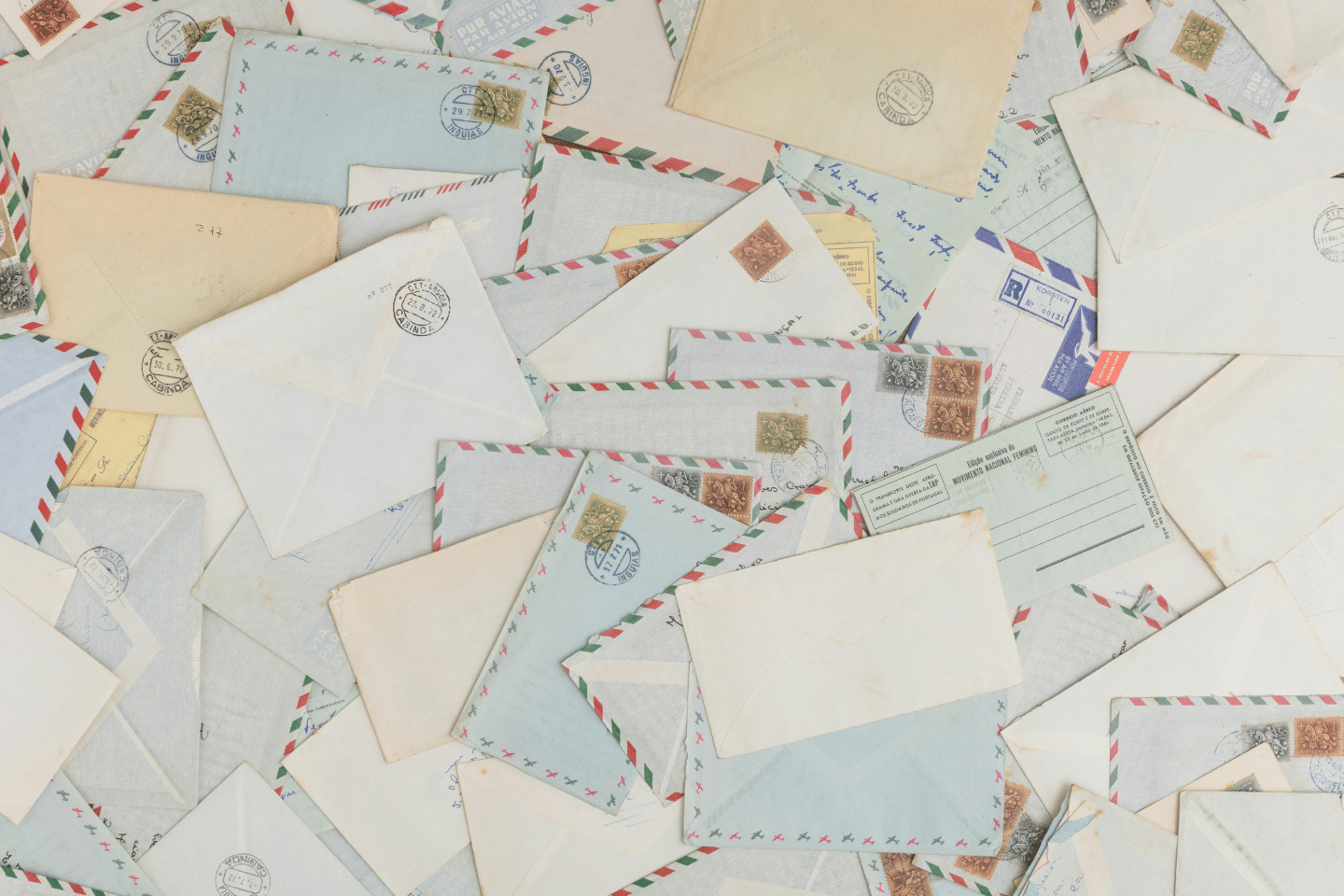 A scattered arrangement of airmail envelopes and vintage letters with postmarks and stamps.