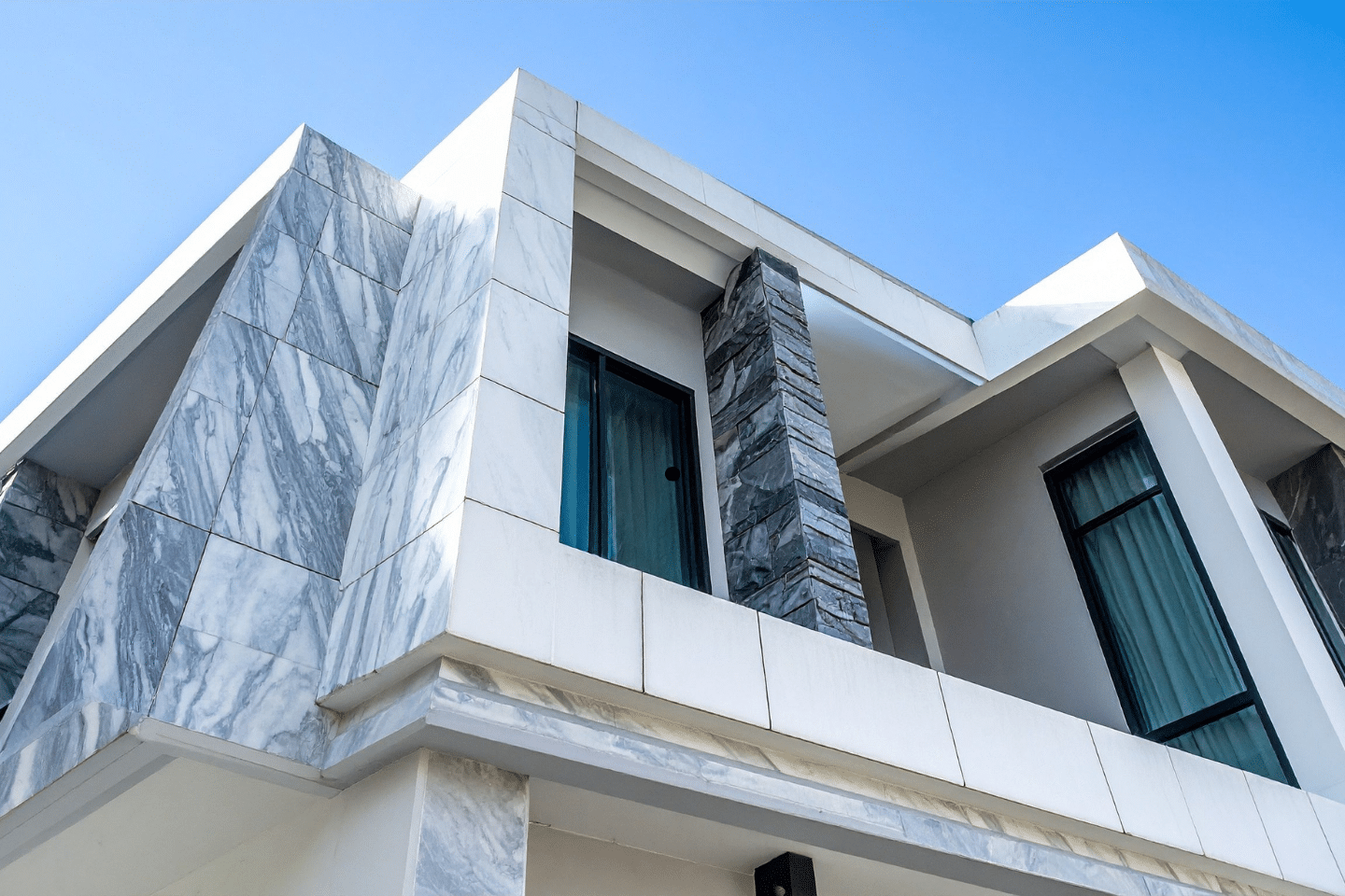 Contemporary house exterior featuring marble panel design and clean architectural lines.