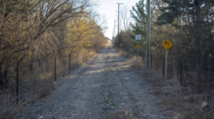 Unpaved utility right of way corridor with overhead power lines illustrating easement and access requirements in Fort Bend County, Texas