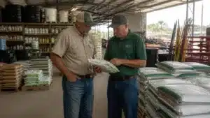Florida agricultural products dealer reviewing fertilizer inventory with a customer to support agricultural operations.