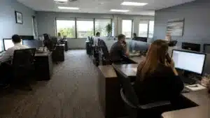 Florida commercial collection agency employees assisting clients and managing commercial debt collection operations in a secure office environment.