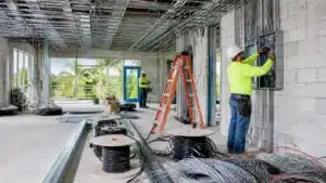 Commercial electrician connecting wiring in an electrical distribution panel during construction