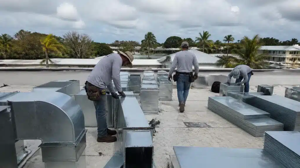 Commercial HVAC contractors assembling rooftop air duct systems for a new construction project