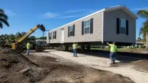 Heavy equipment placing a manufactured home on its foundation under a Florida trailer placement permit bond.