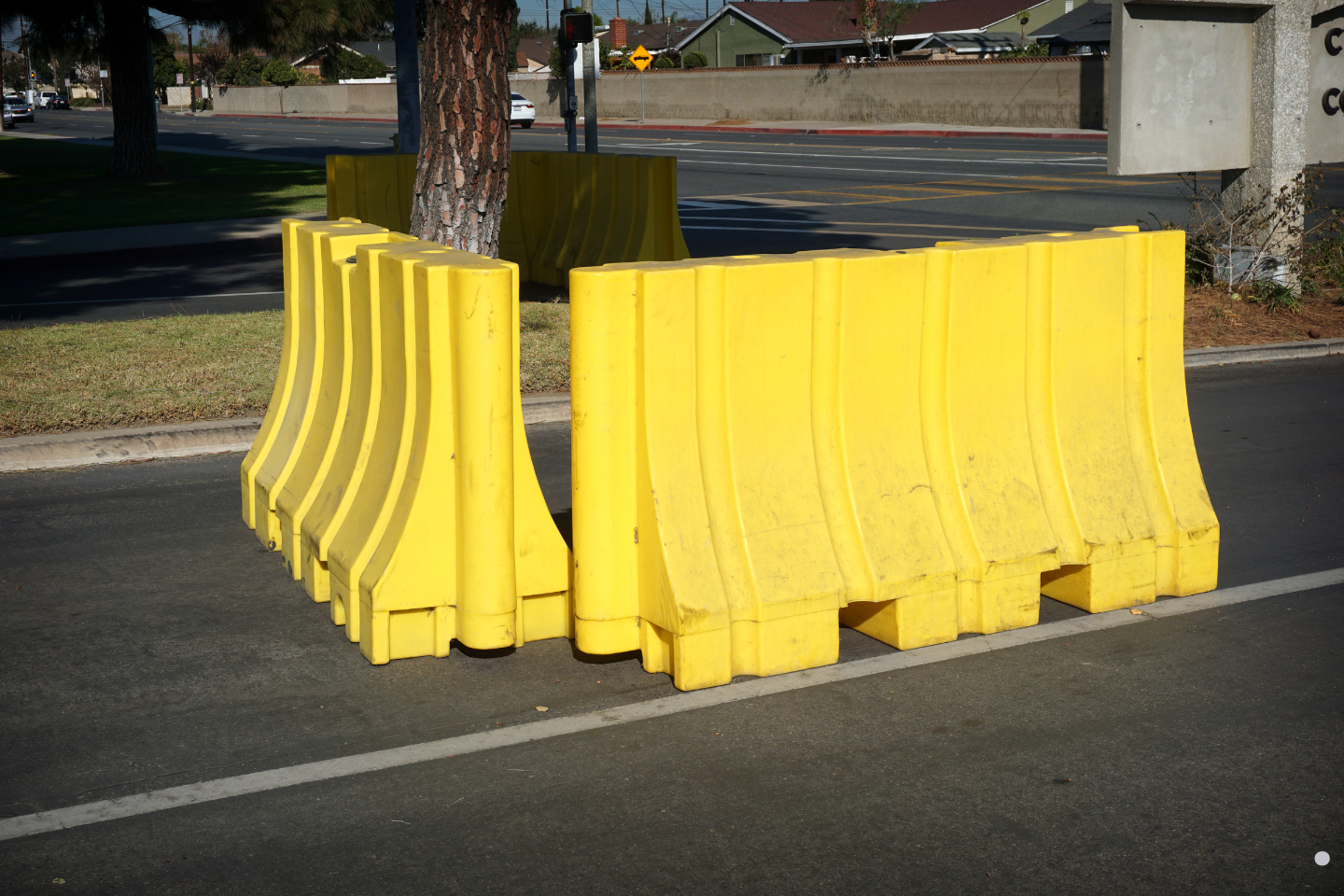 Yellow plastic traffic barriers arranged together on a city street.