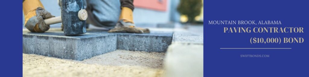 Mountain Brook, AL-Paving Contractor ($10,000) Bond - Builder tamping down a new paving slab or brick with a large mallet in a close up view on the hands and tool.