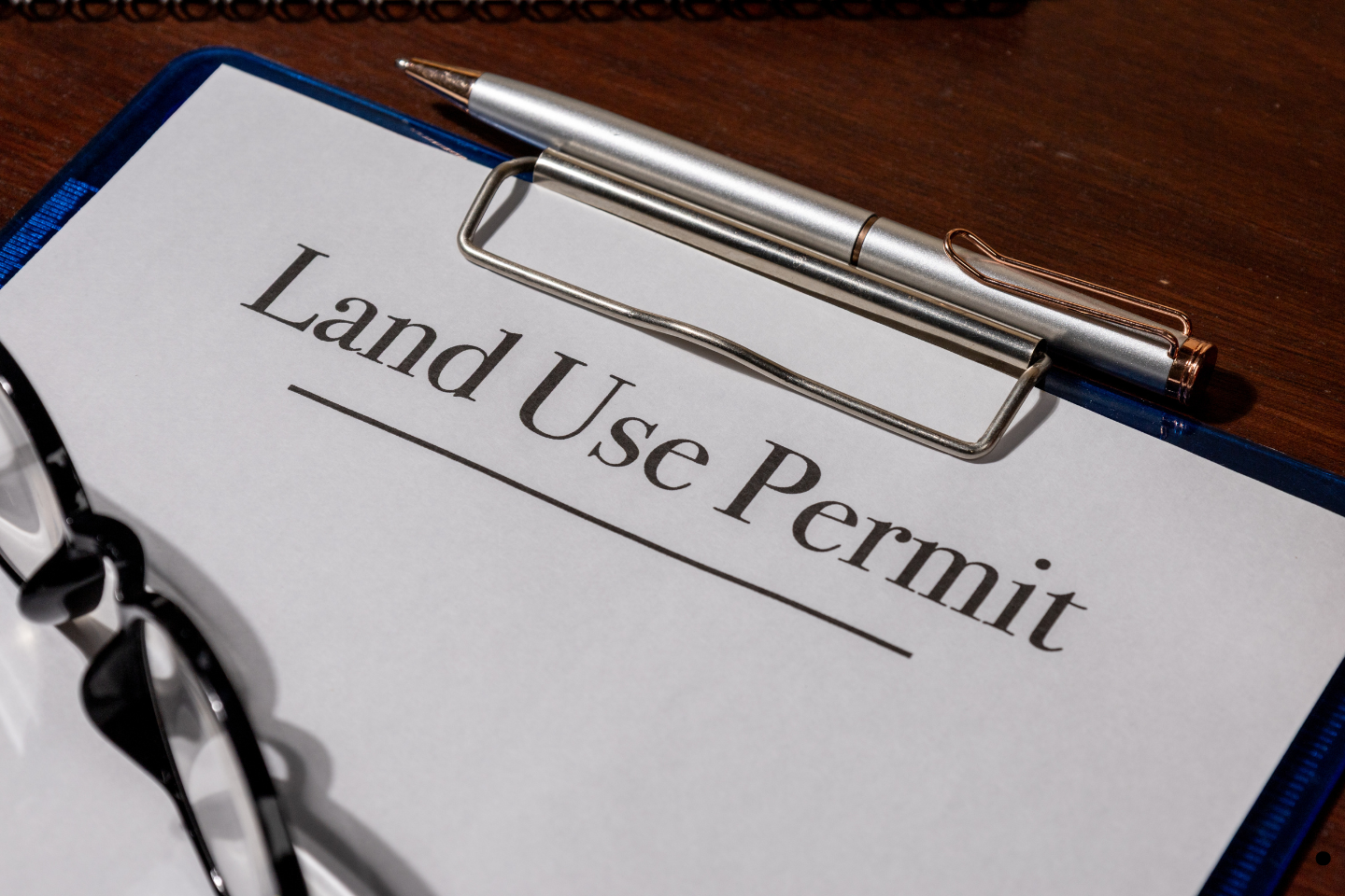 Close-up of a land use permit form clipped to a board with a pen resting on top.