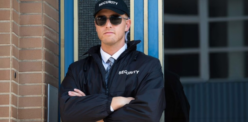 Security guard in uniform standing at building entrance representing licensed Kansas private security services.