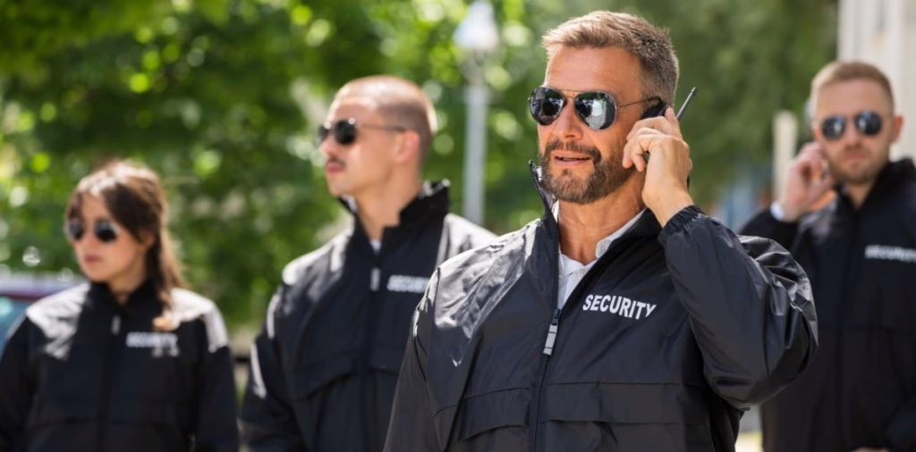 Professional security team outdoors with supervisor using radio communication during active patrol operations.