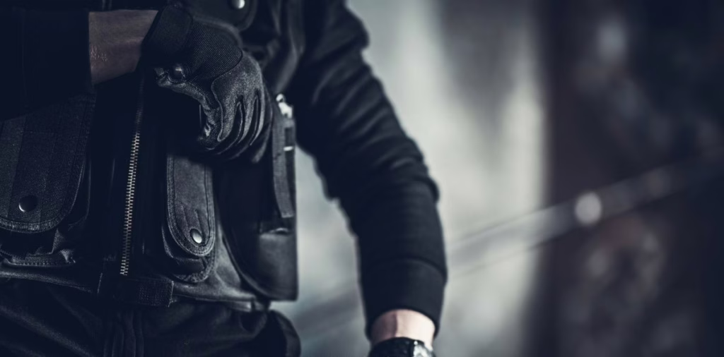 Close-up of armed security officer uniform and duty gear prepared for protection services.