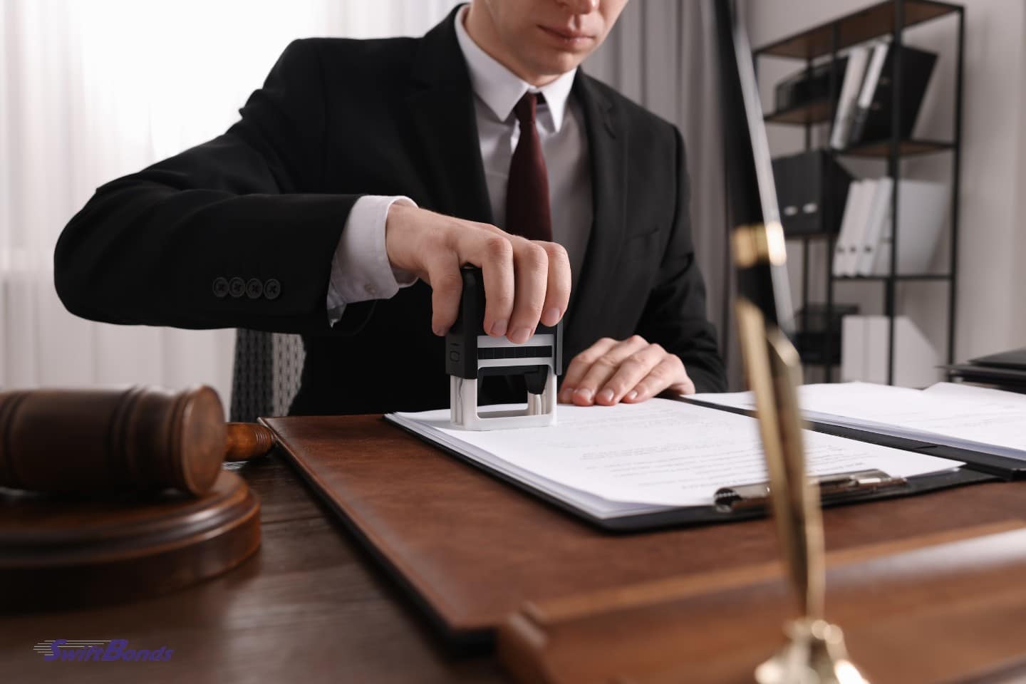 A notary stamps a paper at the office's wooden table.