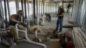 Florida plumbing contractor fitting PVC drain pipes during commercial construction project.