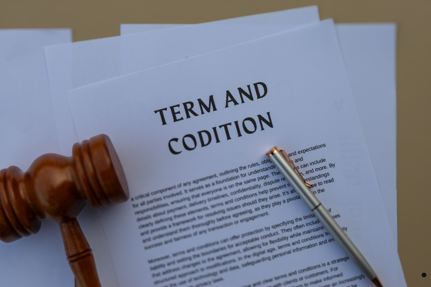 A terms and conditions document with a gavel and pen resting beside it.