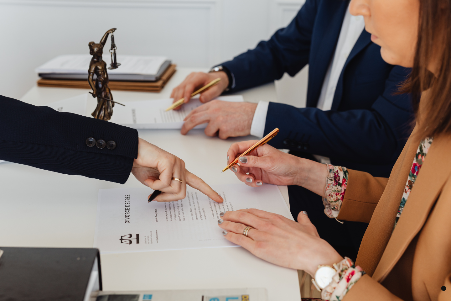 A legal consultation where individuals are reviewing and signing official documents with guidance.