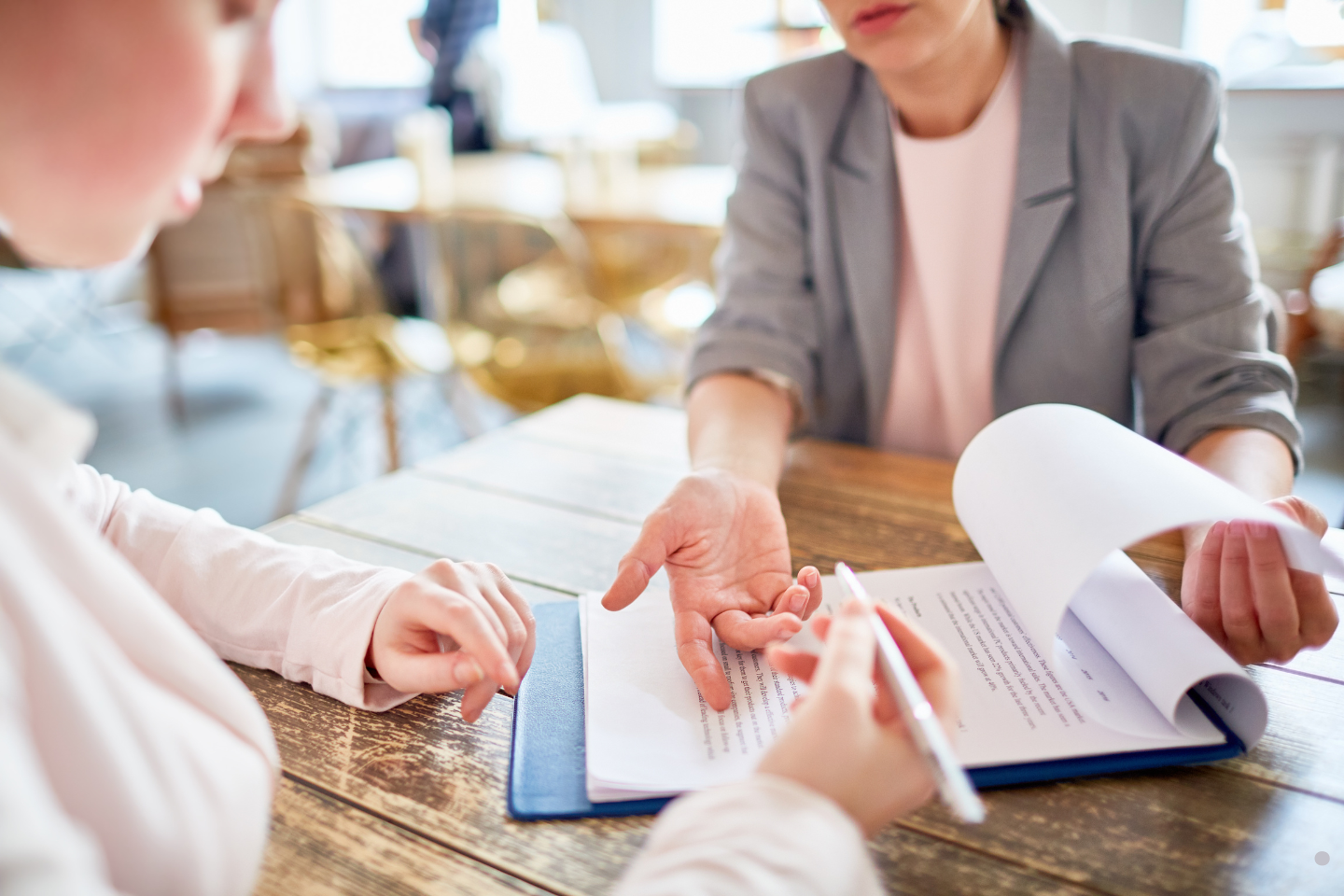 A person reviewing and signing paperwork during a consultation at a table.