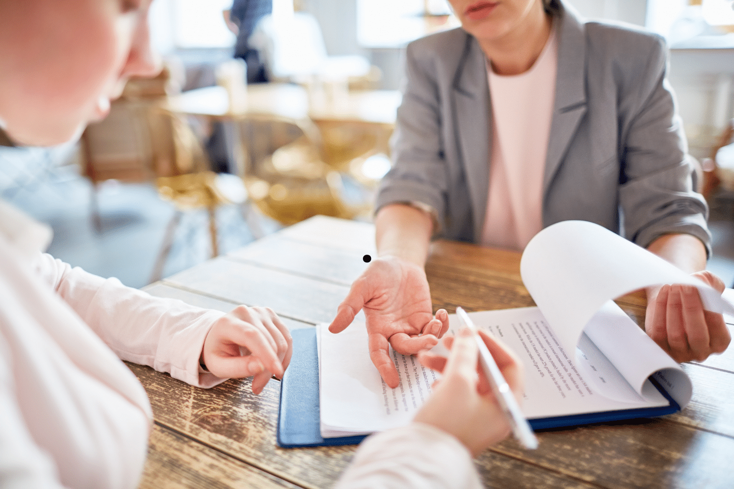 Two people reviewing and discussing a contract document at a table.