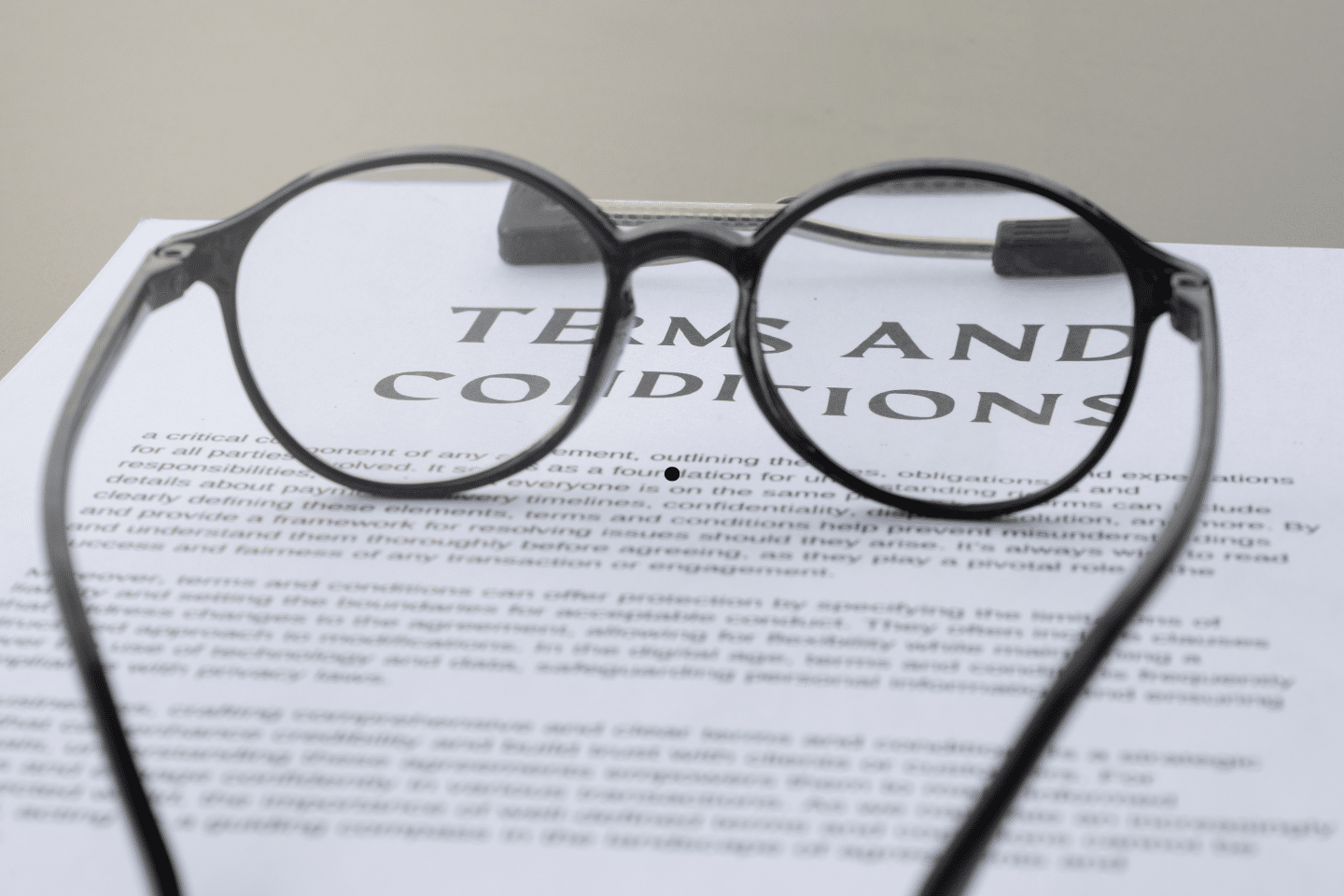 A pair of eyeglasses resting on a document labeled “Terms and Conditions.”