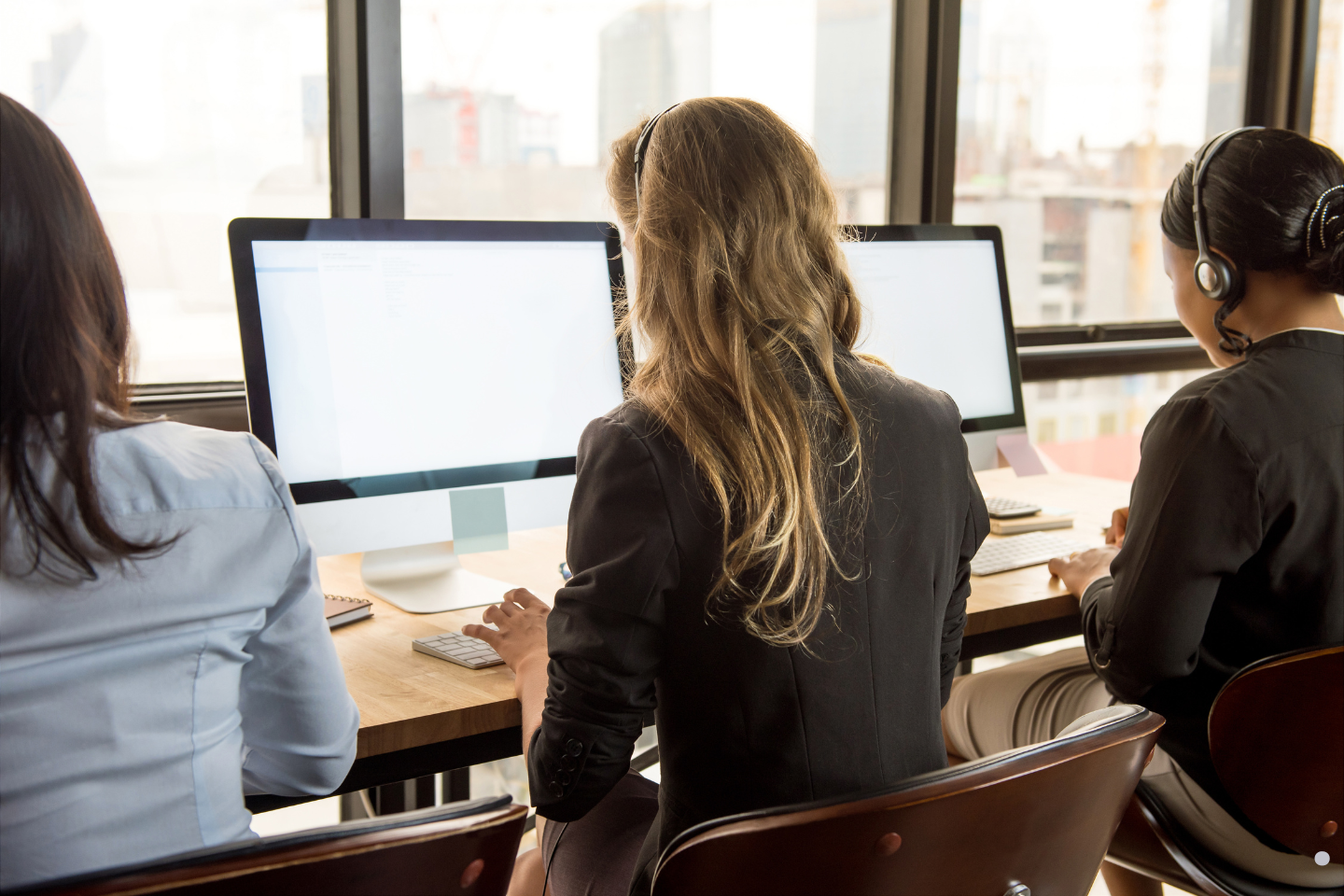 • Telemarketing professionals seated at a row of monitors while handling calls.