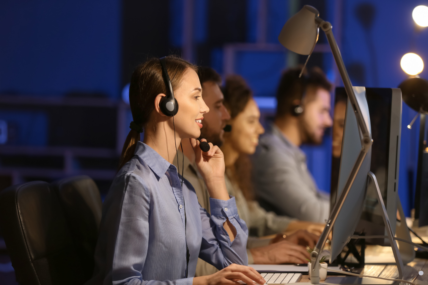 • Call center agents wearing headsets while assisting customers on desktop computers. 
