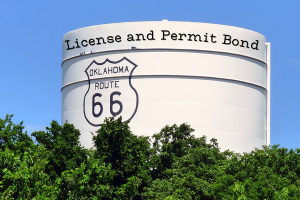 Oklahoma Route 66 water tower displaying 'License and Permit Bond,' symbolizing bonding requirements for businesses in Oklahoma.