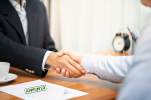 An illustration showing a business owner shaking hands with a regulatory official, symbolizing compliance and trust.