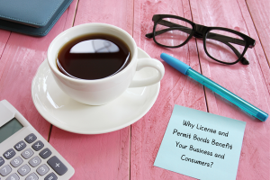 Coffee cup next to a sticky note outlining the benefits of license and permit bonds for businesses and consumers in Iowa.