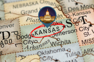 Map of Kansas highlighting the state with a magnifying glass effect, featuring the Kansas State Capitol building in focus.