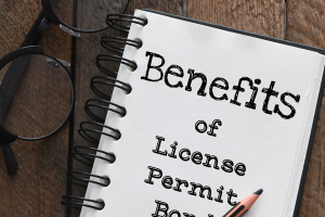 Notebook displaying 'Benefits of License and Permit Bonds' with eyeglasses and a pencil, symbolizing business compliance and bond benefits.