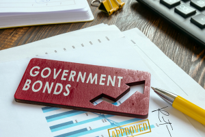 Government Bonds sign on financial documents, emphasizing growth and approval, with a pen and calculator representing financial planning.