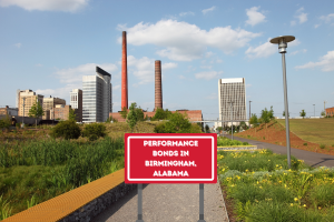 Performance Bonds in Birmingham, Alabama - A pathway in a Birmingham park leading toward the city's industrial skyline, symbolizing the importance of performance bonds in local construction projects.