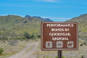 Sign reading 'Performance Bonds in Goodyear, Arizona' with scenic desert mountains in the background, highlighting the local focus of construction bonds in Goodyear.