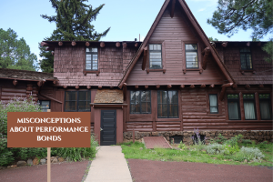 Wooden house in Flagstaff, Arizona with a sign addressing common misconceptions about performance bonds, illustrating the importance of understanding bond terms and conditions in construction projects.