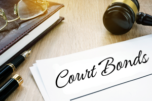 Desk scene with legal materials, including a gavel and a document titled "Court Bonds." The image conveys the importance of court bonds in legal and probate proceedings.