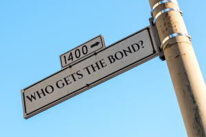 Street sign reading 'Who Gets the Bond?' symbolizing the allocation of probate bonds in estate proceedings.