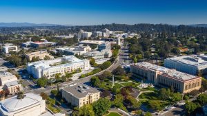 Bird's-eye view of Cupertino, California's downtown area, featuring iconic buildings, tree-lined streets, and a vibrant cityscape.