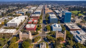 Aerial view of Cupertino, California showcasing urban infrastructure, green parks, and a mix of residential and commercial buildings.