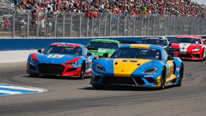 an image featuring Auto Club Speedway's racecars zooming by, surrounded by adrenaline-fueled spectators, highlighting Fontana CA's thrilling race events for a blog post on Top Attractions and Activities.