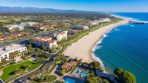 Laguna Niguel’s scenic coastline with luxurious beachfront properties, clear blue skies, and expansive ocean views, representing the area’s beauty and vibrant real estate market.