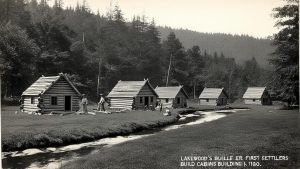 Historic log cabins built by the first settlers of Lakewood, Colorado, showcasing early American architecture surrounded by natural forest scenery.