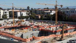 Montebello construction site featuring cranes, workers, and concrete structures under development, highlighting the role of performance bonds in ensuring project completion.