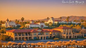 Scenic view of Rancho Santa Margarita, California, showcasing Spanish-style architecture and palm trees under a warm sunset.