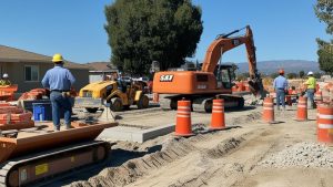 Construction workers and heavy machinery at a residential project site in Rancho San Jacinto, California, showcasing active development and infrastructure growth.