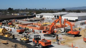 Construction site in Citrus Heights, California with orange excavators, machinery, and workers actively engaged in building foundation structures.