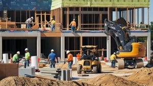 Construction workers on-site at a building project in Cicero, Illinois, with cranes, scaffolding, and materials highlighting active development.